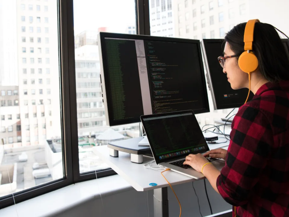 Developer writing code across multiple monitors